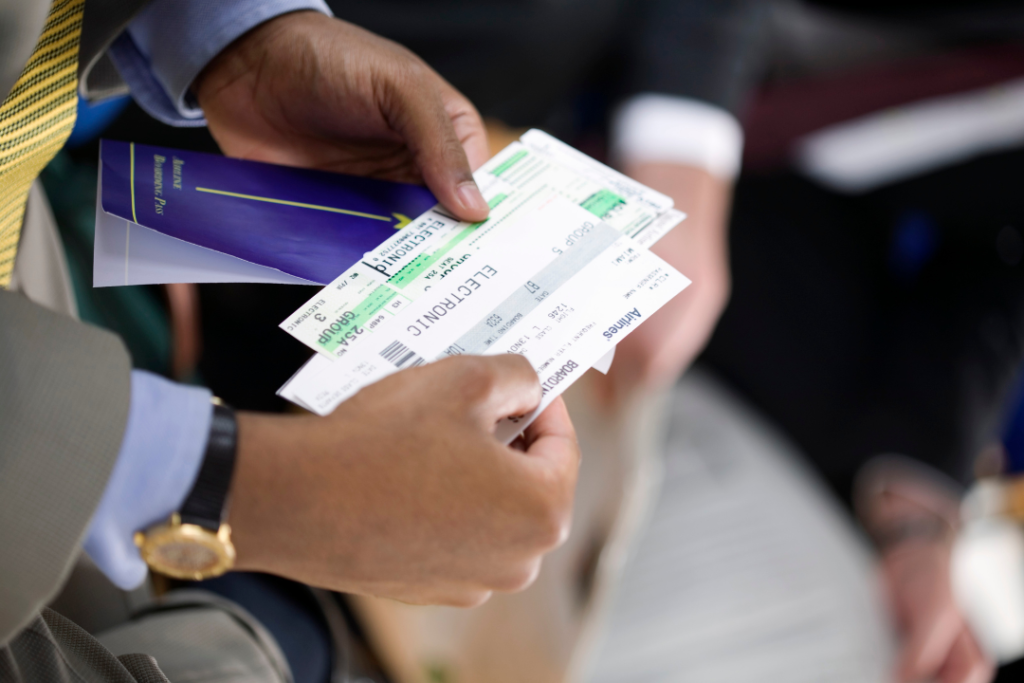 persona con tarjetas de embarque de avion en la mano.